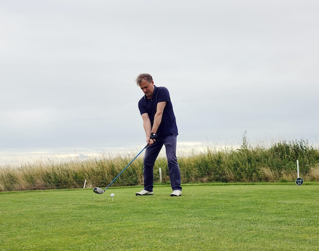 A golfer preparing to tee off on a coastal golf course